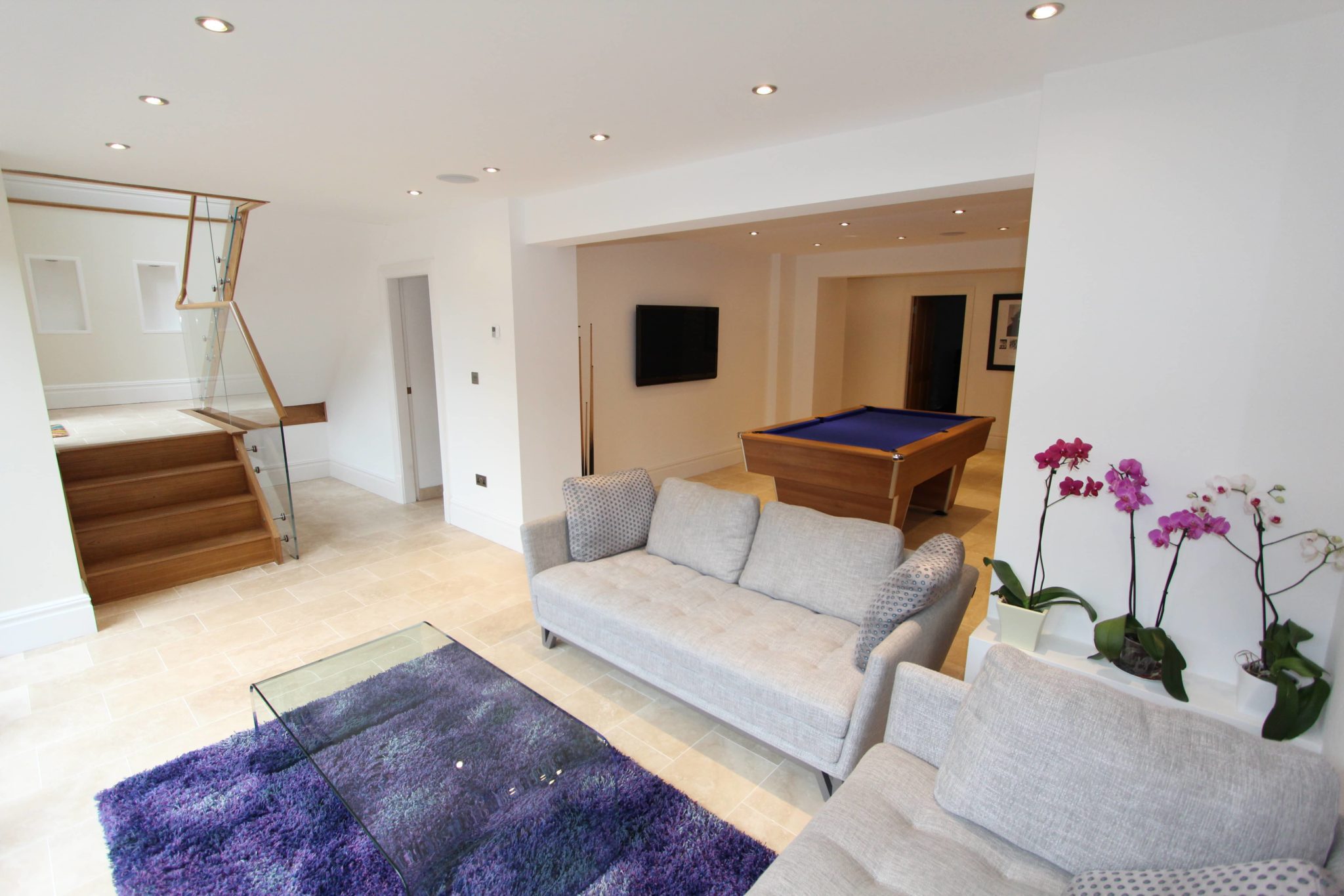 a living room filled with furniture and a pool table.